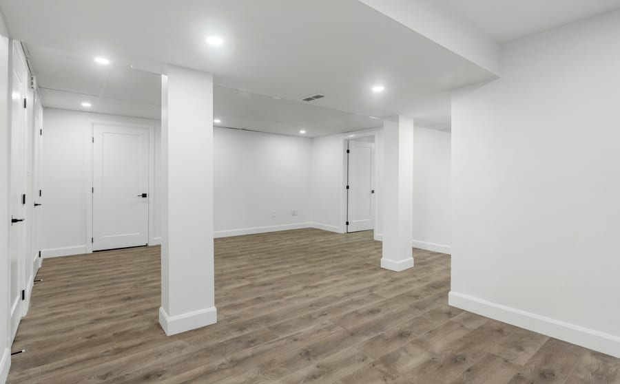 A finished basement with light walls and a wood floor