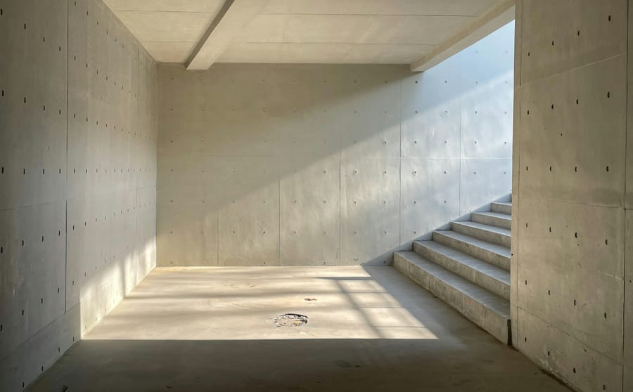 A bare concrete stairwell lit from one side