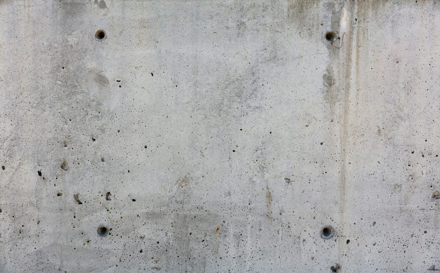 A close view of poured concrete showing form-tie holes